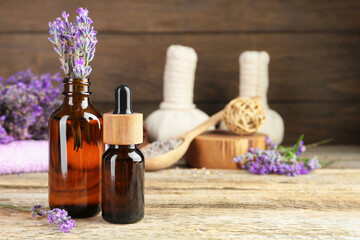 Lavender essential oil and flowers on wooden table