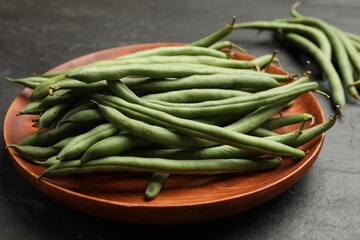 Many raw green beans on black table, closeup