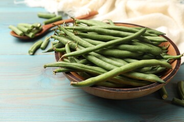 Many raw green beans on blue wooden table, closeup