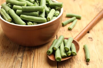 Many raw green beans on wooden table, closeup