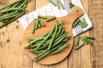 Many raw green beans on wooden table, flat lay