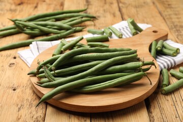 Many raw green beans on wooden table, closeup