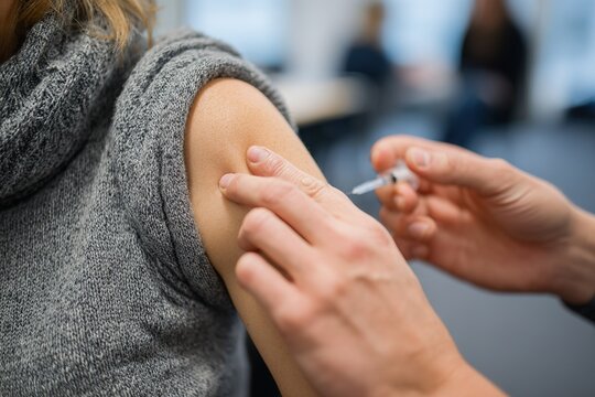 Healthcare professional administers vaccination to patient in a modern clinic setting during daytime