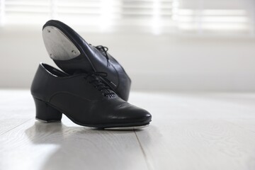 Pair of shoes for tap dance on floor indoors, closeup. Space for text © New Africa