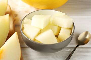 Cut ripe melon on white wooden table, closeup