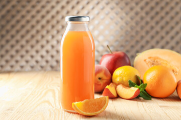 Tasty juice in glass bottle, fresh fruits and mint on wooden table indoors, closeup