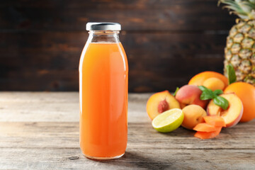 Tasty juice in glass bottle, fresh ingredients and herbs on wooden table against brown background, closeup