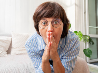 Surprised caucasian adult female with glasses in blue striped shirt