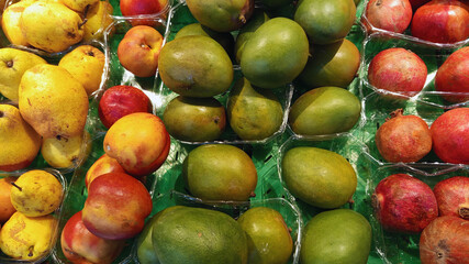 Close up photo of various type fresh fruits arrange neatly grocery store quince avocado mango peach on rack background horizontal hd resolution image poster banner background perfect for campaigns 