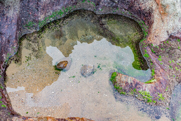 top view of small lake with calm, clean and clear water at edge of a mountain
