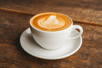 Obraz premium Beautiful latte art in white cup on saucer, perfect for cafe lovers, coffee enthusiasts, and cozy morning beverages