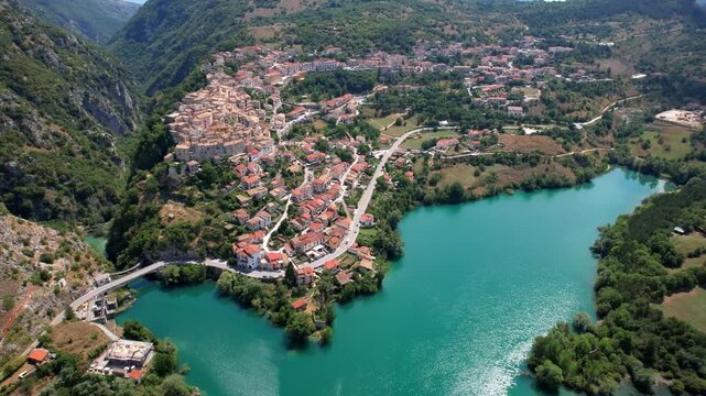 Cinematic drone reveal of Barrea medieval borgo and lake, Abruzzo National Park, Italy 4K establishing shot. Sangro Valley landscape. B-roll for travel documentary. Most beautiful italian villages 