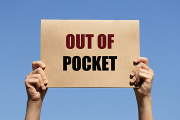 Out of pocket text on paper holding by a woman's hand with blue sky background