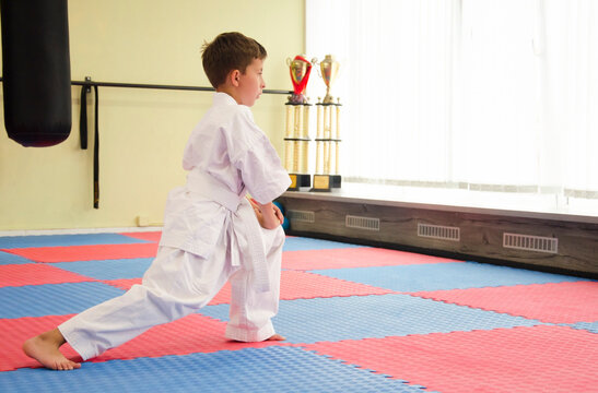 Karate boy doing stretching at workout.Child in kimono. Martial arts. 極真会(Karate Kyokushin)