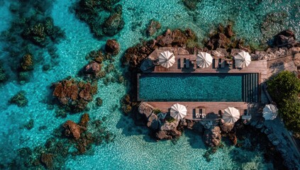 Aerial view of a secluded infinity pool nestled amongst rocks and turquoise water