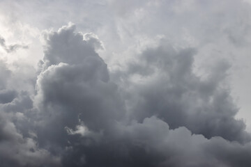 An atmospheric photo of clouds just before the rain starts. Dark clouds have gathered in front of the sun. 