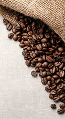Rich roasted coffee beans spilling from burlap sack onto textured fabric surface