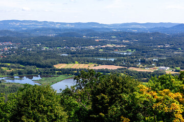 Scenic view of green mountains, fields, and lakes under a clear sky