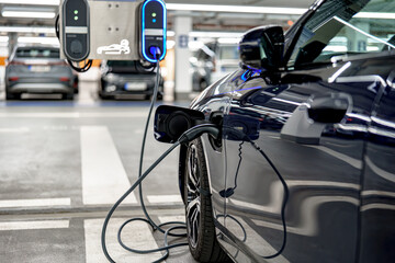 Electric car charging at a station in an underground parking facility during daytime hours