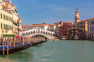 Rialto Bridge over Grand Canal with gondolas and historic buildings in Venice Italy