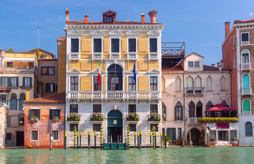 Traditional Venetian canal house with balconies and moored boat on Grand Canal in Venice Italy
