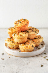 Savory zucchini muffins with cheese and seeds on a plate on white table background isolated. Healthy and quick morning breakfast