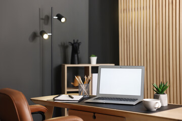 Fototapeta premium Stylish workplace with laptop and stationery on wooden table in office