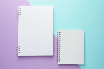 White notebooks on color background, flat lay
