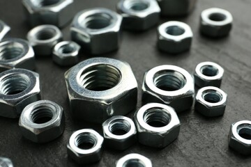 Metal hex nuts on black table, closeup