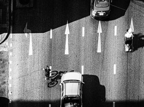 Top view of busy street with arrow signs in monochrome  