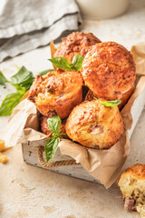 Savory egg muffins with bazil, ham and cheese in white wooden box on kitchen table background. Healthy and quick morning breakfast