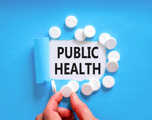 Public health symbol. Concept words Public health on beautiful white paper. White pills tablets. Doctor's hand. Beautiful blue background. Medical healthy lifestyle public health concept.