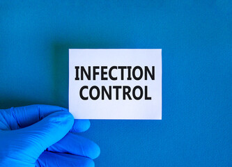 Infection control symbol. Concept words Infection control on beautiful white card. Doctor's hand in blue medical glove. Beautiful blue background. Medical healthy lifestyle infection control concept.