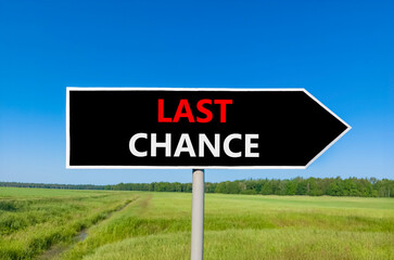 Last chance symbol. Concept word Last chance on beautiful black road sign. Beautiful green grass field blue sky background. Business last chance concept. Copy space.
