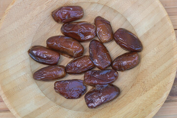 Fresh Dark Brown Dates in Rustic Wooden Bowl