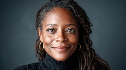 A confident woman with dreadlocks smiles softly against a minimalist backdrop. Her warm expression and relaxed demeanor showcase strength, beauty, and empowerment in simplicity.