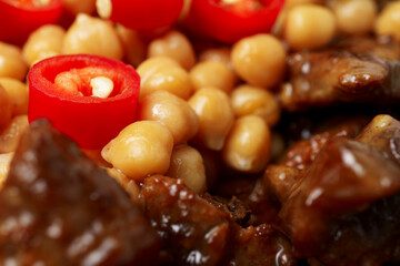 juicy grilled meat served with chickpeas, red chili pepper, and fresh herbs. Rich textures and vibrant colors highlight the freshness