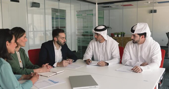 Merger. Multicultural business parties signing legal contract documents during negotiation in boardroom, finalizing formal meeting successfully, shaking hands, expressing respect, concluding agreement