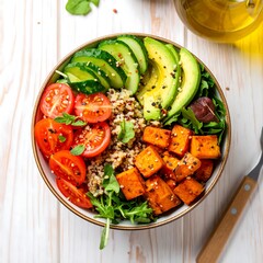 Colorful quinoa bowl with roasted sweet potato, avocado, cucumber, and cherry tomatoes