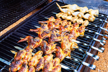 Juicy chicken wings grilling on barbecue at outdoor fire pit during summer cookout celebration