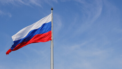The Russian flag flutters in the wind. The Russian flag against the blue sky..The Russian flag. High quality photo