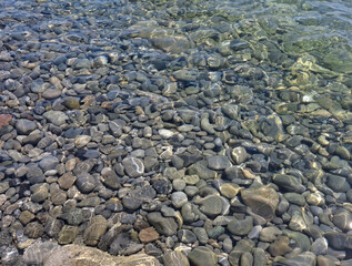 stones on the bottom of the sea's clear water