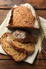 Pieces of fresh bread and spikes on wooden table, flat lay