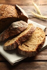 Pieces of fresh bread and spikes on wooden table, closeup