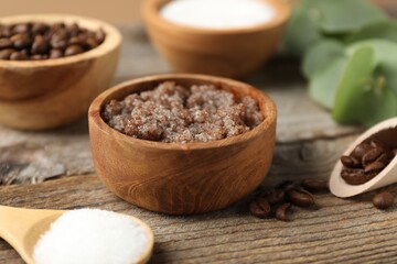 Natural body scrub and coffee beans on wooden table, closeup