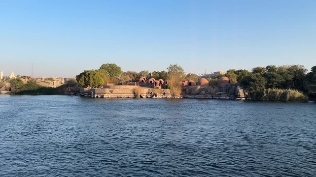 Serene boat ride on the historic Old Cataract stretch of the Nile River in Aswan, Egypt, surrounded by desert and river scenery.
