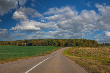Autumn landscape and sunny evening, orange road and highway, asphalt and roadside.