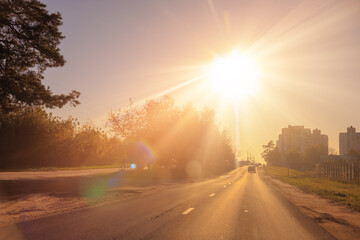 Autumn landscape and sunny evening, orange road and highway, asphalt and roadside.