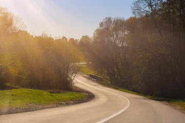 Autumn landscape and sunny evening, orange road and highway, asphalt and roadside.