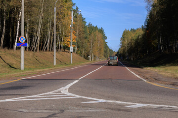 Autumn landscape and sunny evening, orange road and highway, asphalt and roadside.